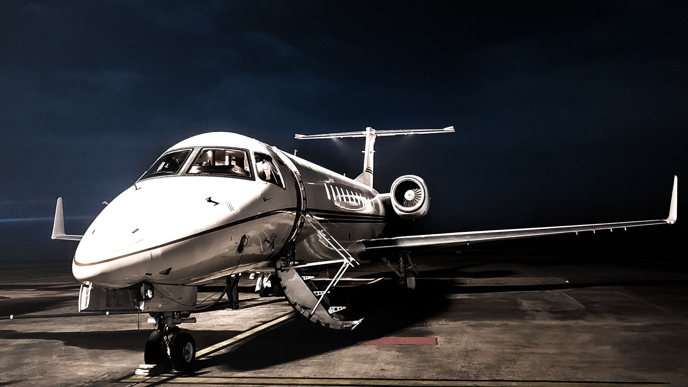 Private jet with open airstair on a night apron
