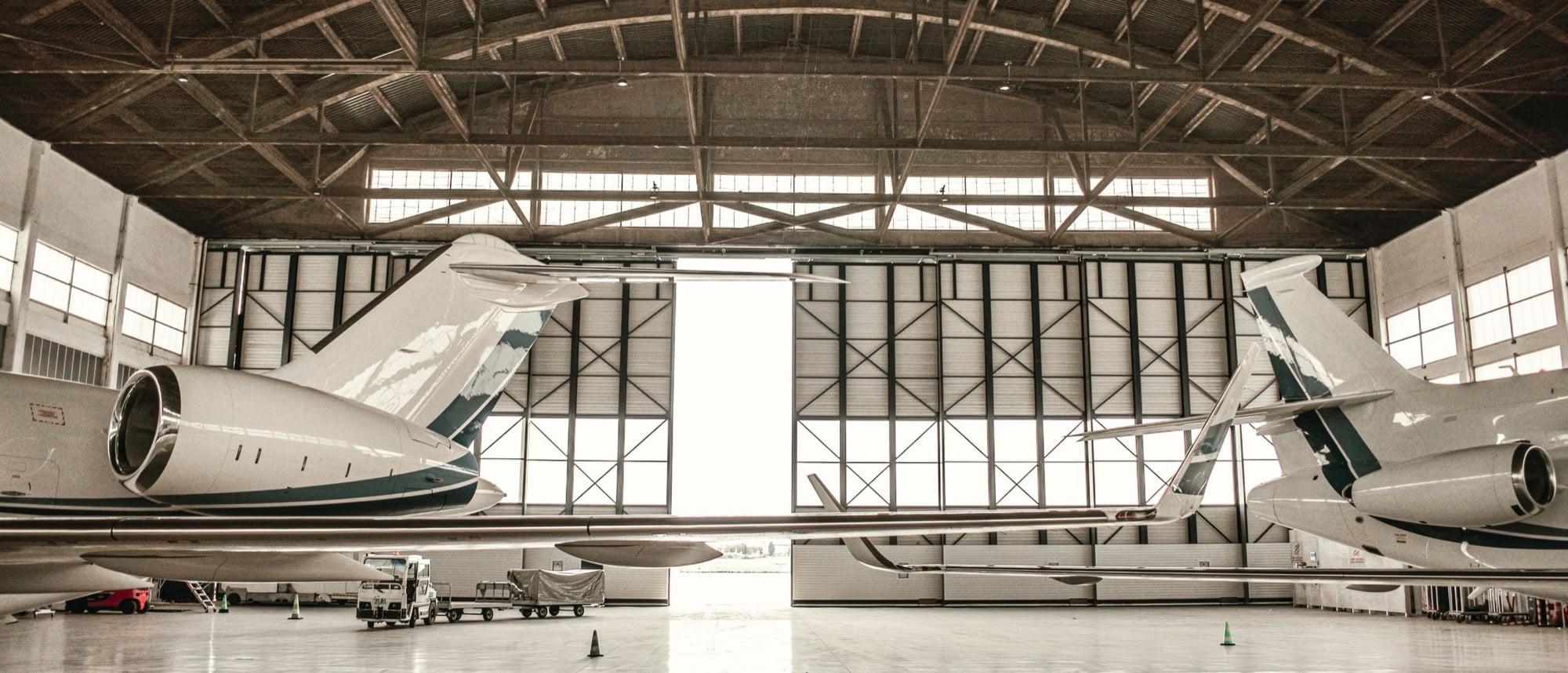 Business jets resting inside a private hangar